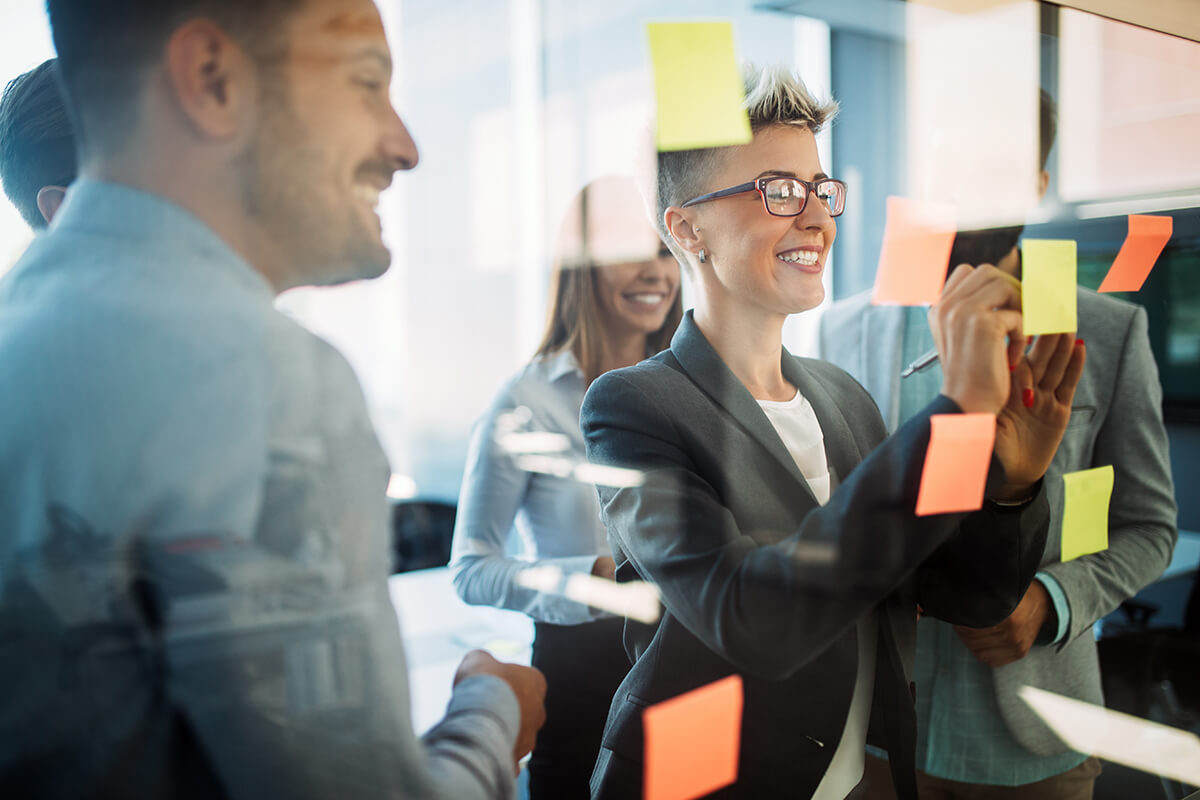 People at an office placing sticky notes on glass window