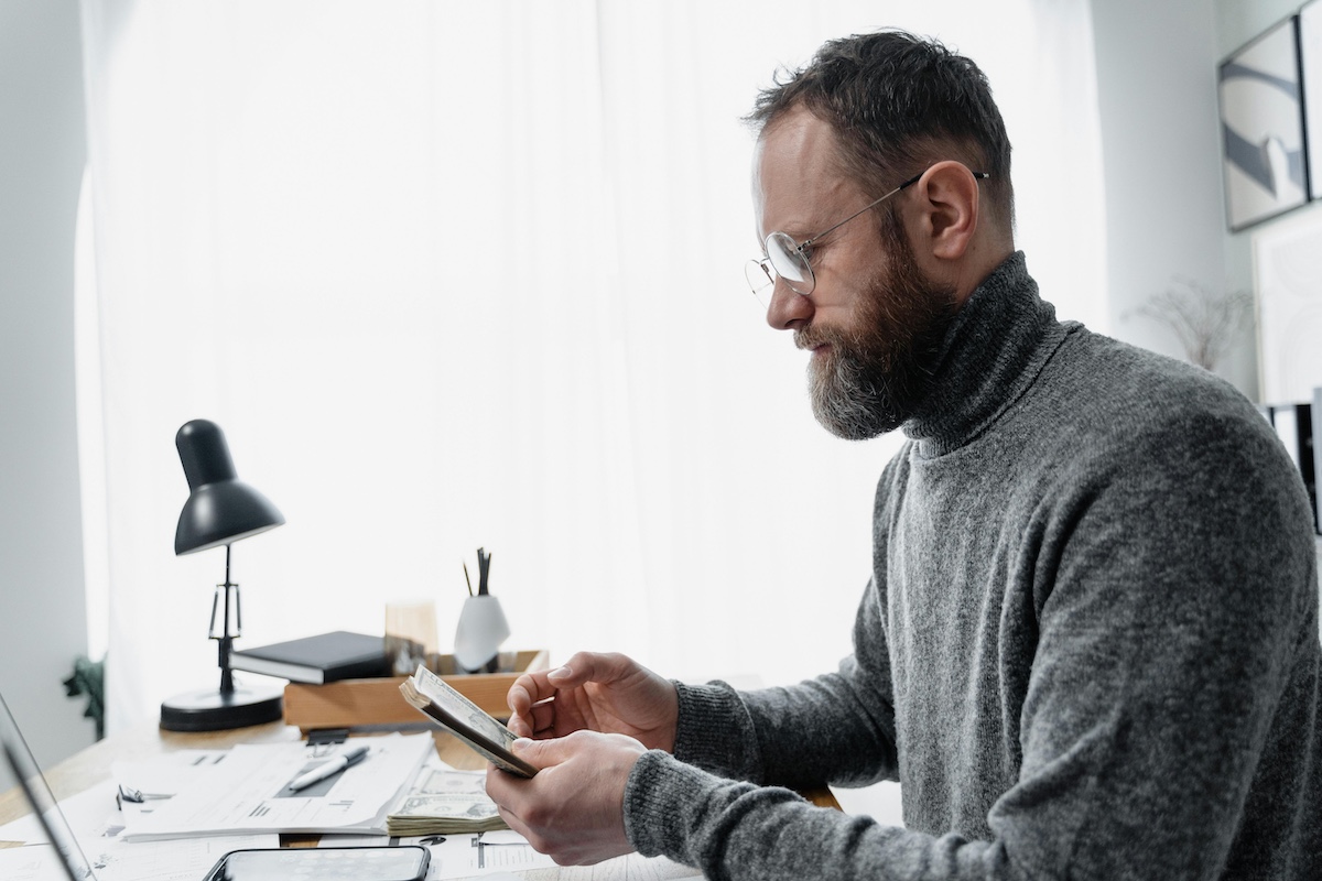 Man counting money at a desk