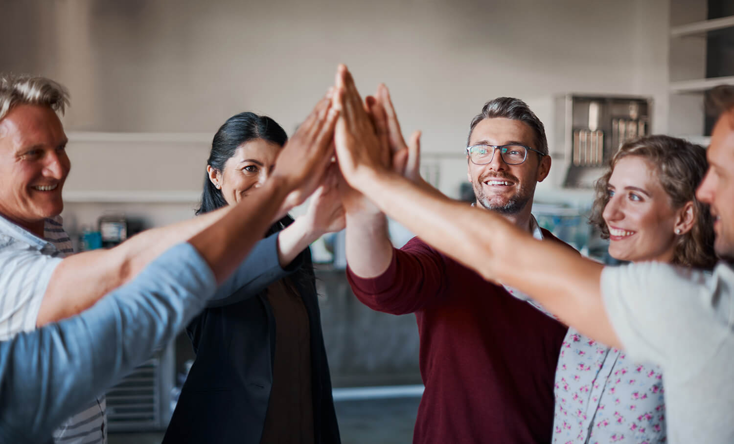 Group of people at an office slapping hands