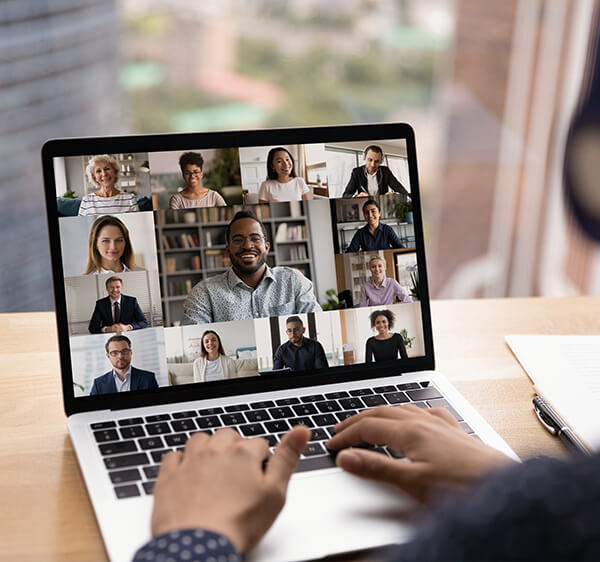 A Laptop Screen Showing 13 Professional Team Members on a Virtual Meeting Using Webcams