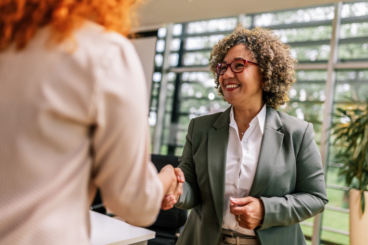 Two professional women shaking hands after a job interview