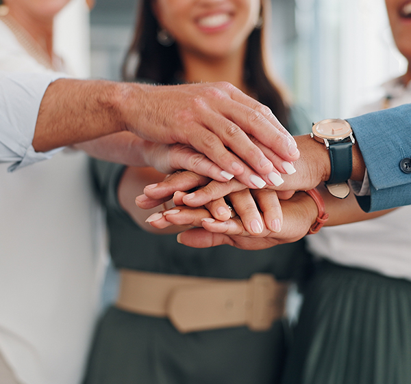 Close Up of Hands Stacked In Team Huddle